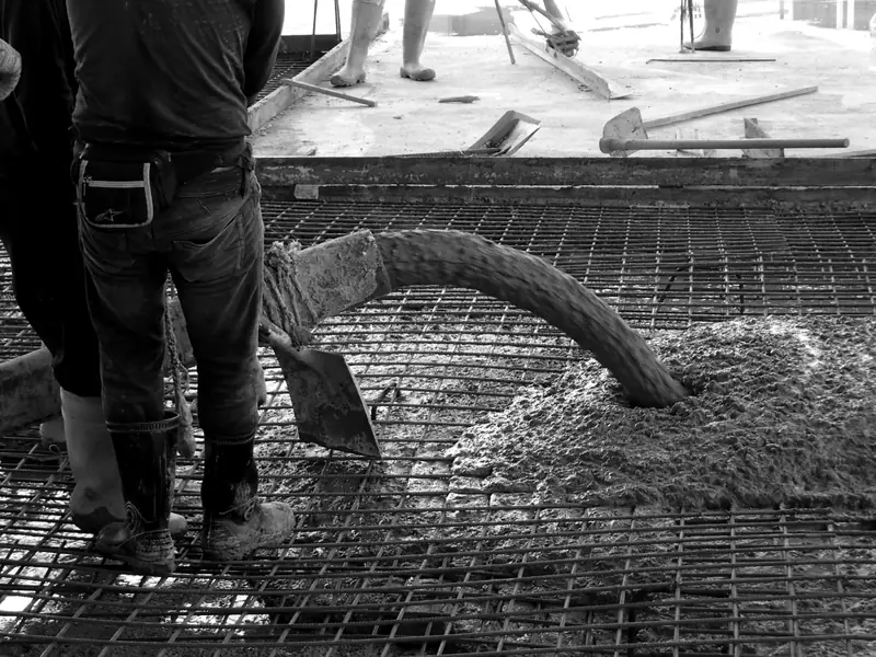 Concrete pump hose placing concrete over rebar mesh